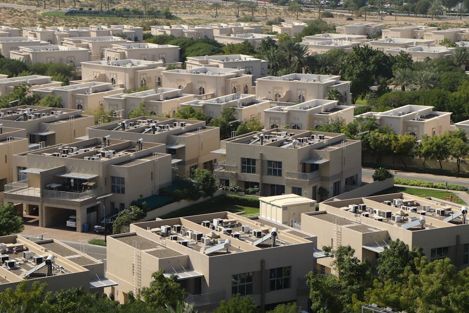Aerial view of modern residential villas surrounded by greenery in Dubai.