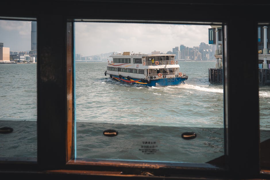 View of the Star Ferry crossing Victoria Harbour, iconic Hong Kong skyline in the background.