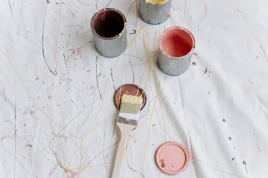 Artistic top-view photo of paint cans and splashes on a canvas, perfect for modern and abstract themes.