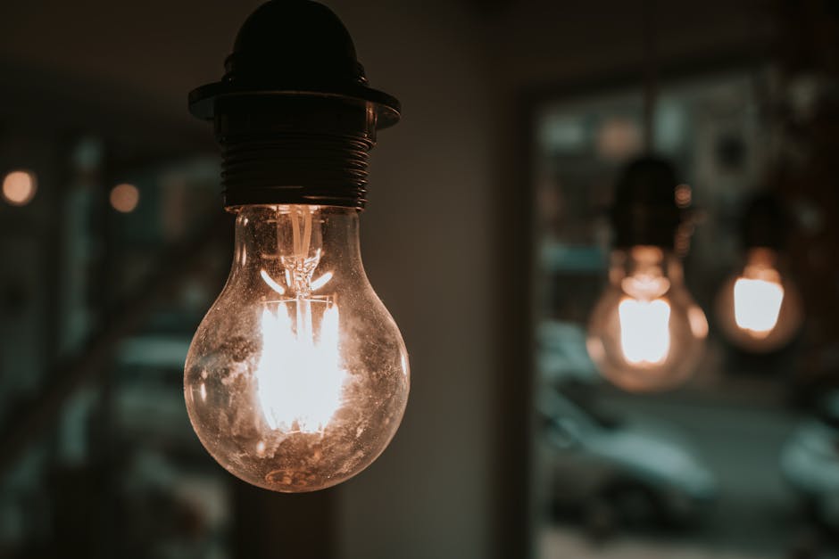 An artistic close-up of illuminated hanging light bulbs in a cozy indoor setting.