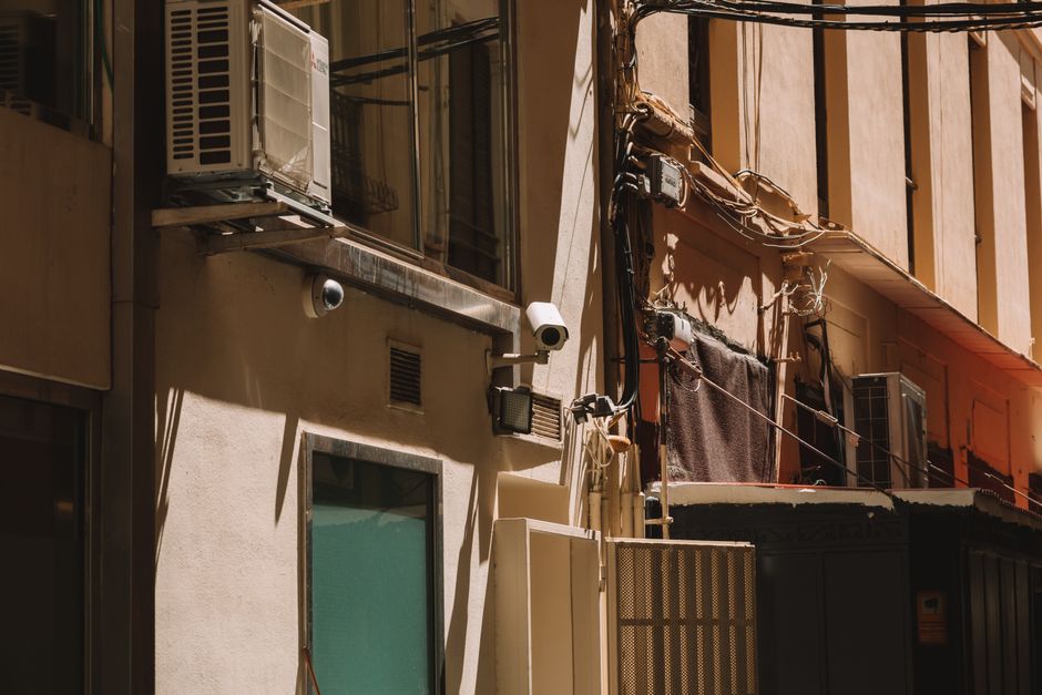 Urban building with security cameras and air conditioning units in Valencia, Spain.