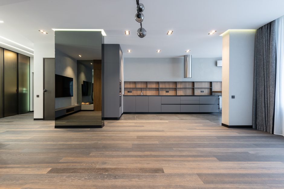 Modern unfurnished apartment with free space looking into dining area and mirrored pillar