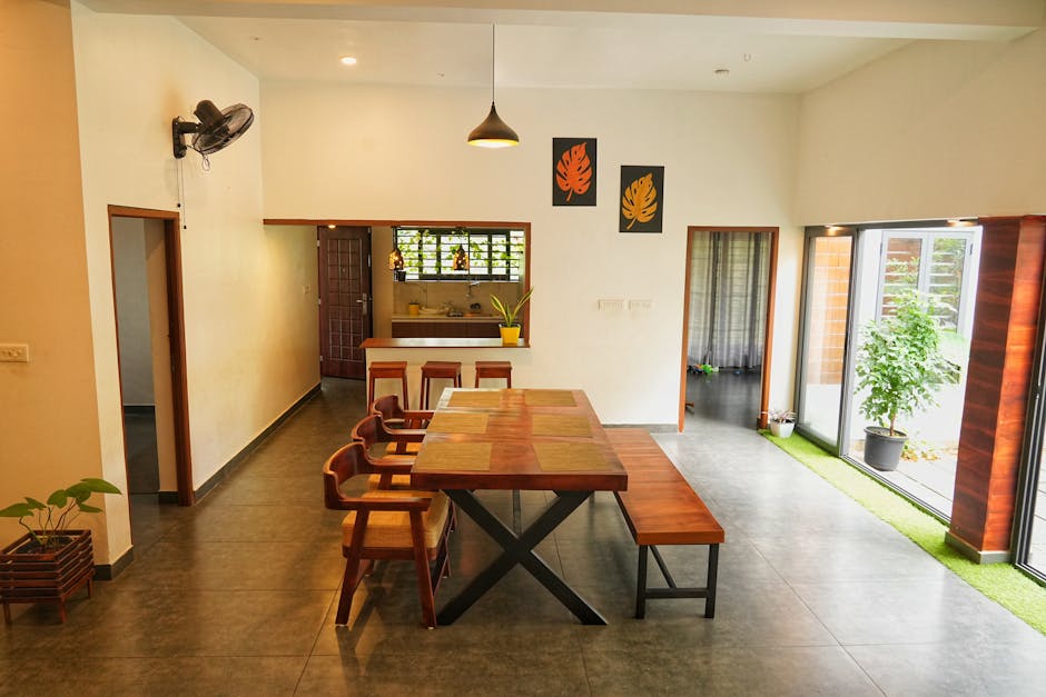 Modern dining area in a Kerala home featuring wooden furniture and vibrant decor.