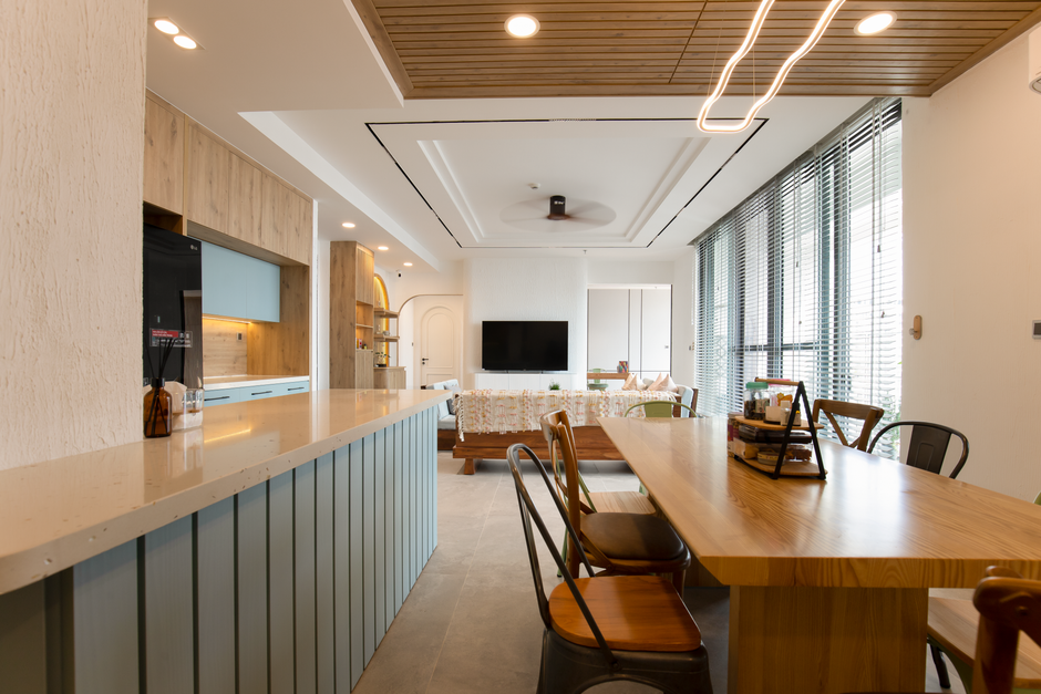 Spacious modern living room with open kitchen and wooden furniture, natural light.