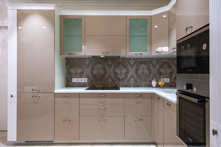 Contemporary kitchen with beige glossy cabinets and built in oven and microwave in column under bright lights