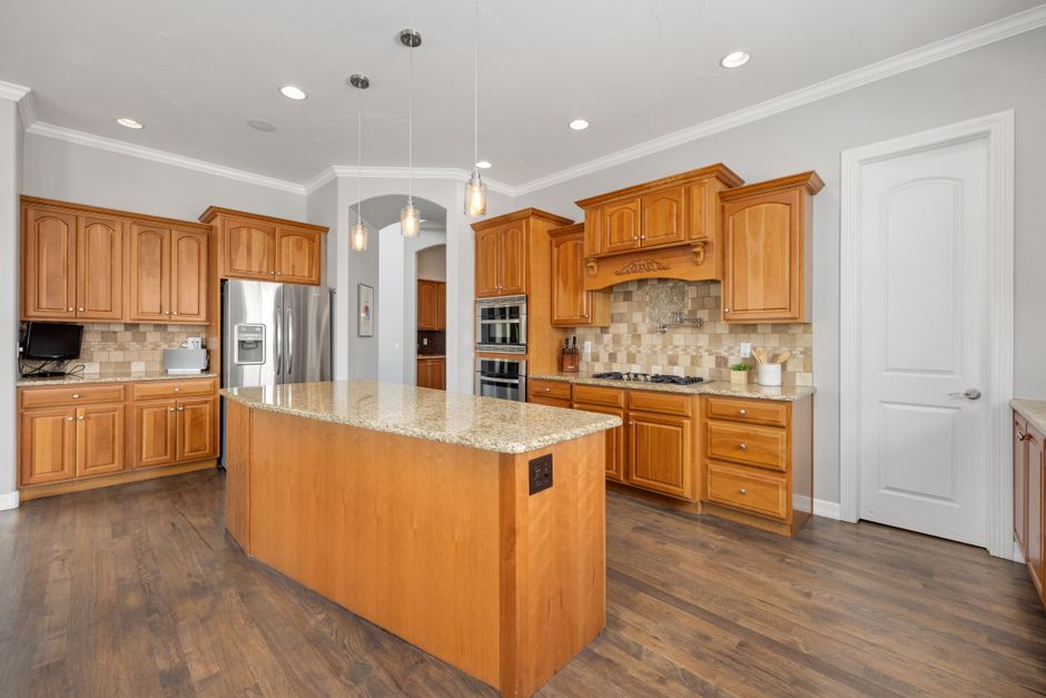 Bright kitchen featuring a granite island and wooden cabinetry, ideal for contemporary homes.