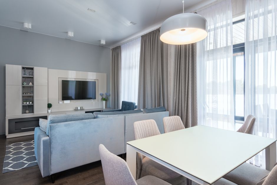 Bright and spacious modern living room featuring elegant minimalist decor with blue and gray tones.