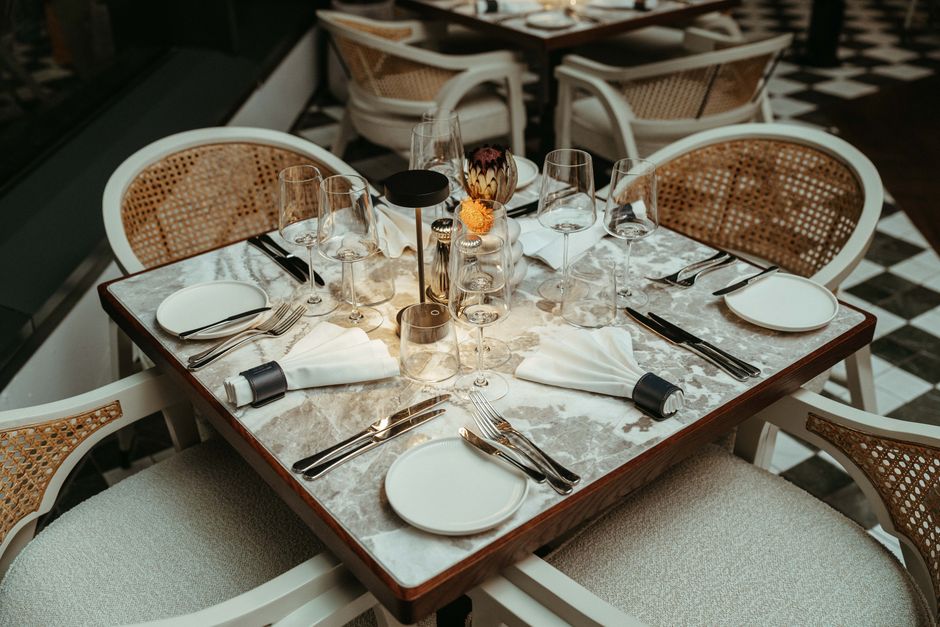 Elegant dining setup with modern decor in Cape Town, featuring glassware and floral centerpiece.