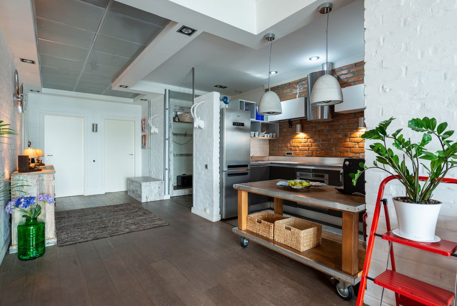 Stylish kitchen featuring brick walls, stainless steel appliances, and indoor plants.