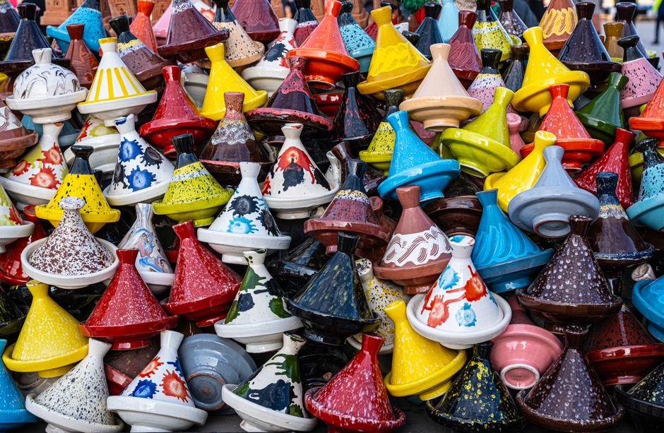 Vibrant artisanal tagine pots on display in Marrakesh market showcase Moroccan craftsmanship.